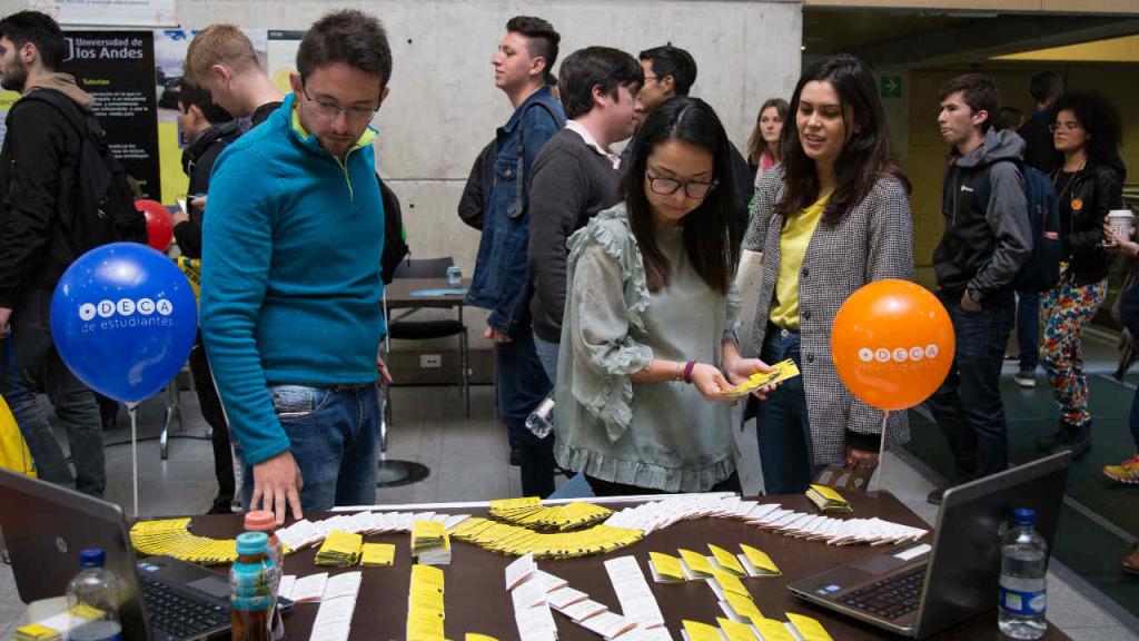 Jovenes observando sobre una mesa en una feria. 