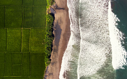 Un prado verde junto a un mar con muchas olas.