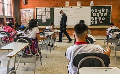 Confianza: la clave para un retorno seguro a las aulas Foto de estudiantes de colegio en un aula de clases durante la pandemia