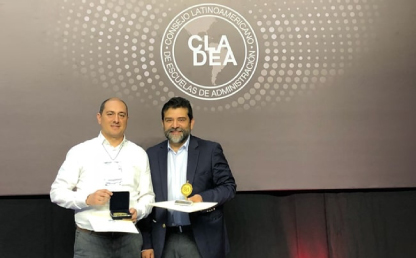 El decano de la Facultad de Administración, Eric Rodríguez, recibe el reconocimiento.