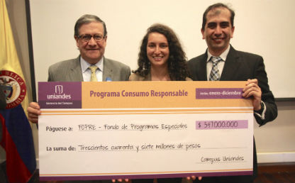 dos hombres y una mujer de pelo crespo sostienen un cheque muy grande de donaciones para becas estudiantiles