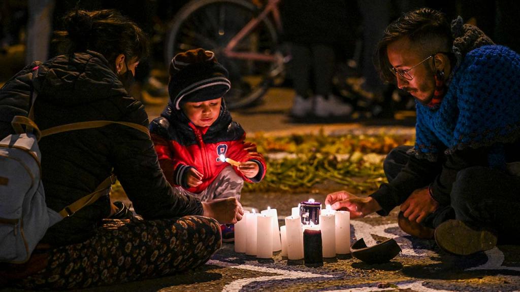 Una familia prende velas.