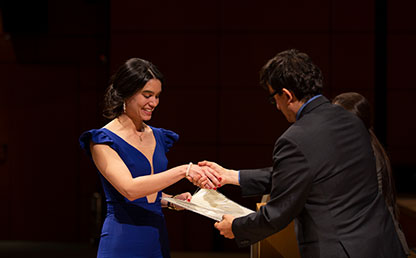 Mujer de vestido azul recibe diploma