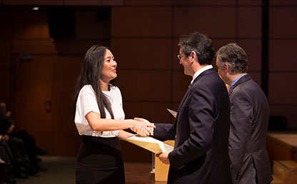 Mujer, vestida de blanco, recibe diploma de la Universidad de los Andes