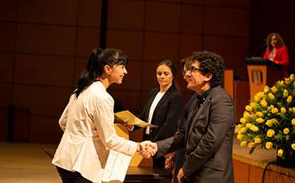 Mujer recibiendo diploma de grado de la Universidad de los Andes