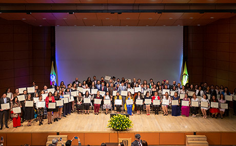 Graduandos ceremonia de posgrados posando en grupo para foto