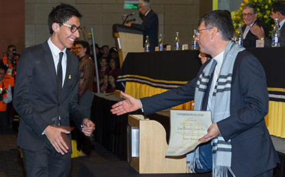 Graduando recibe diploma en ceremonia de grados Uniandes
