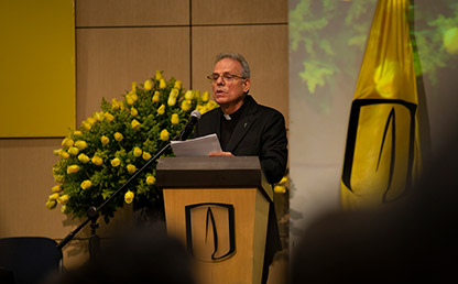 Sacerdote ofreciendo discurso en atril de Uniandes