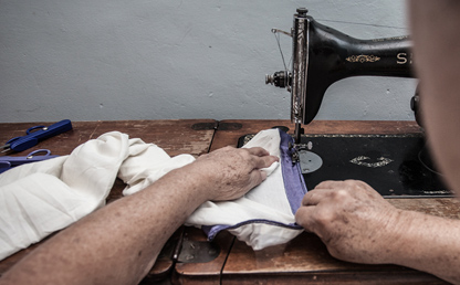 Manos de una anciana sobre una máquina de coser