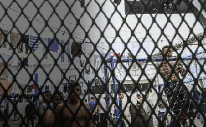 hombres en la cárcel vistos a través de reja de reclusión