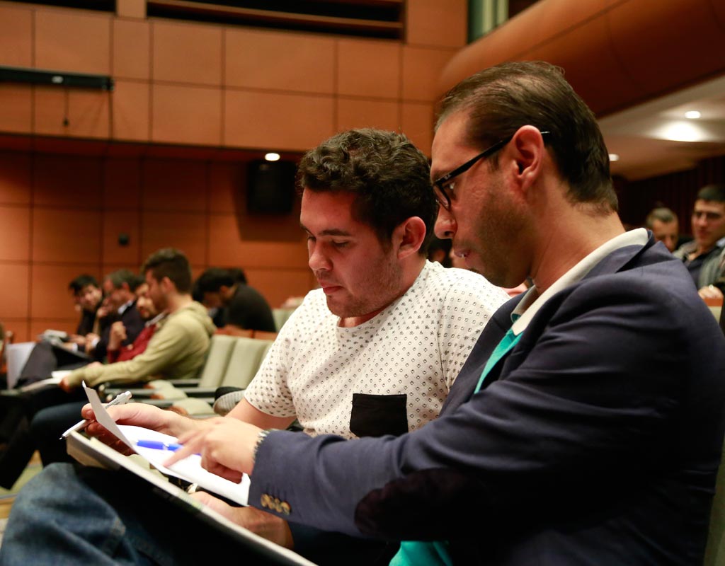 Dos personas en un auditorio revisan un cuaderno.