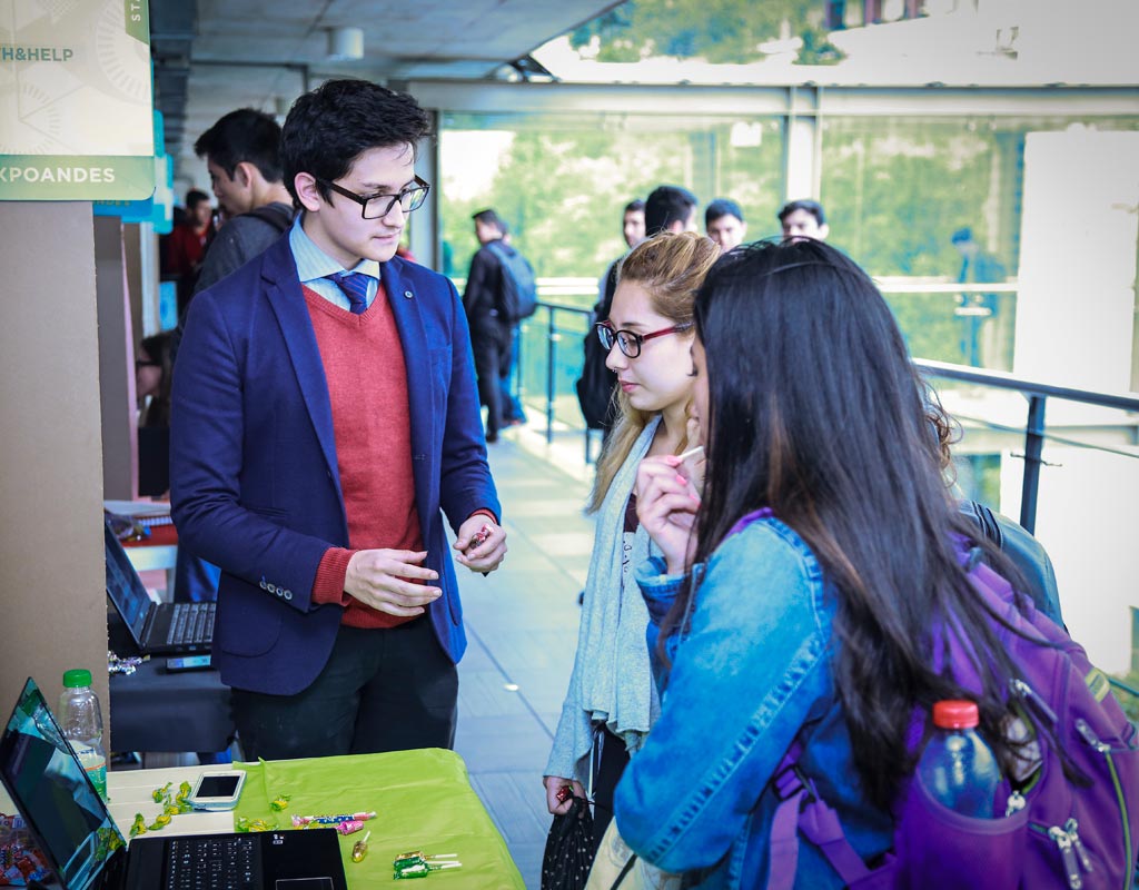 Estudiantes en un stand exponen sus trabajos 