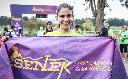 Mujer celebra luego de ganar en la carrera Senek 2016.
