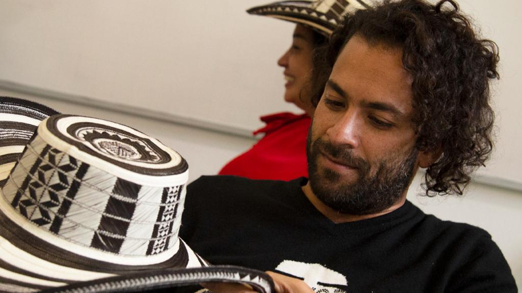 Joven estudiante observando un sombrero vueltiao que tiene en sus manos