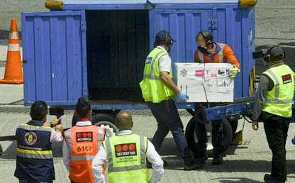 Personas cargando caja con vacunas en un container